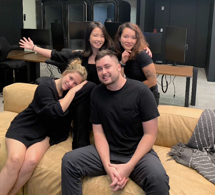 Hinge team members posing together on a tan leather couch in the office